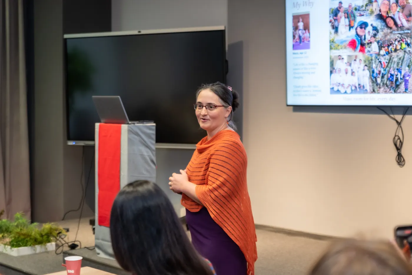 Oana Garcia smiling toward her audience while speaking in a workshop room